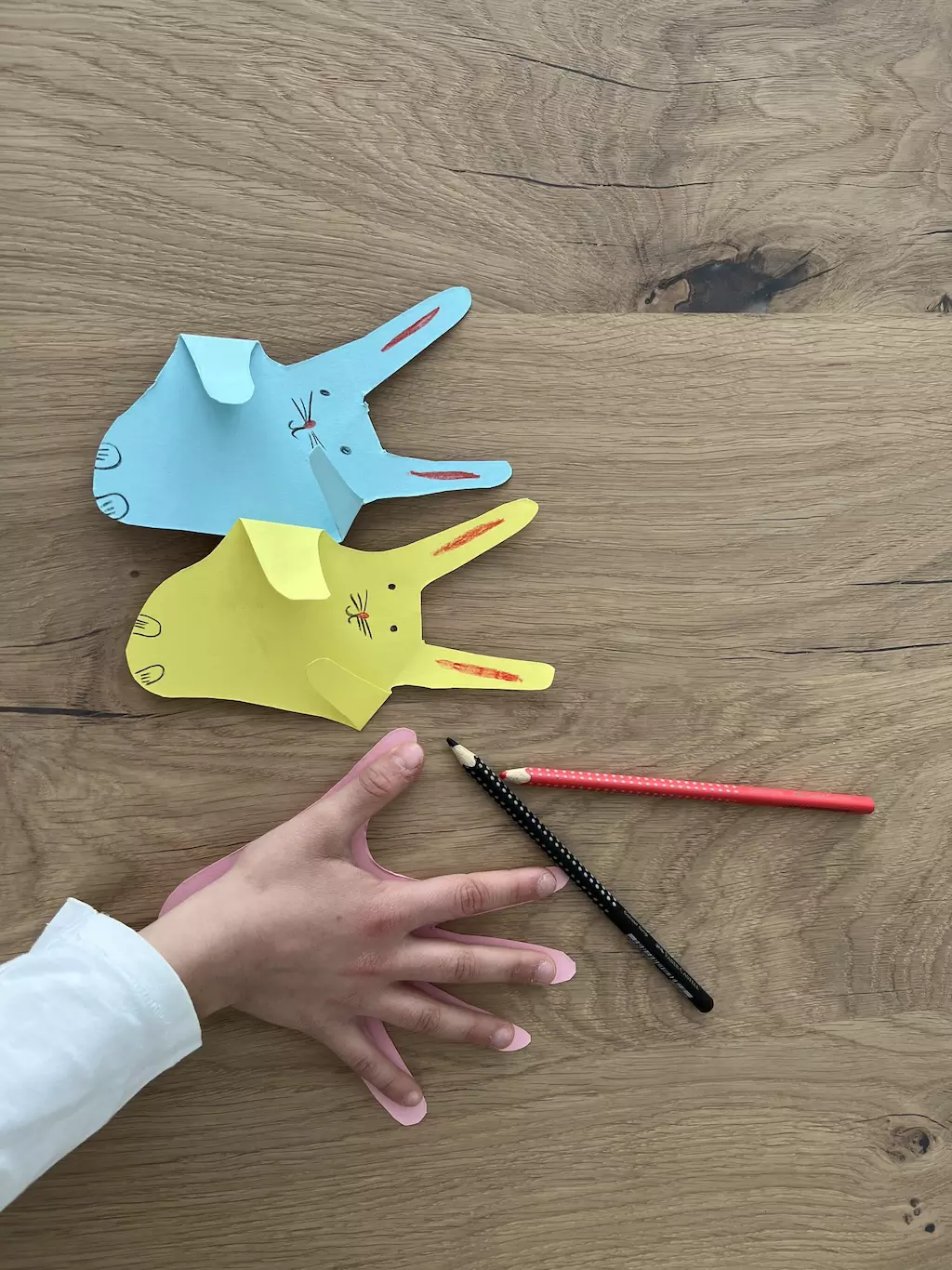 Kreative Osterhasen aus Papier. Einfaches Basteln mit Handabdruck für Kinder. Benötigt nur Tonpapier, Schere und Stifte – perfekt für zu Hause